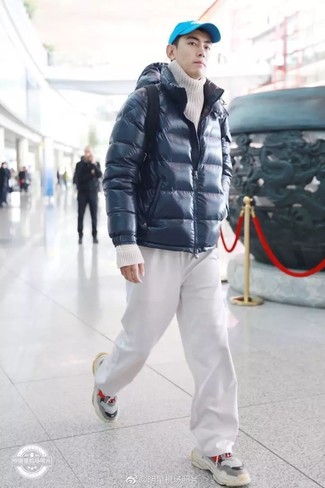 Модный лук: темно-синяя куртка-пуховик, белая вязаная водолазка, белые спортивные штаны, серые кроссовки