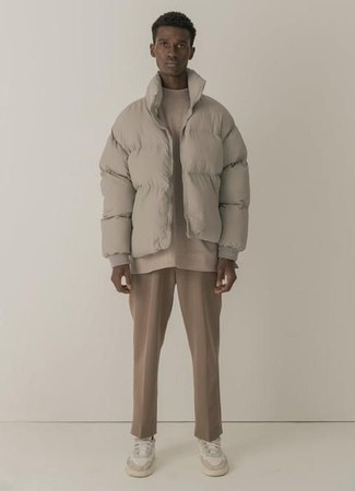 Модный лук: бежевая куртка-пуховик, бежевая футболка с круглым вырезом, светло-коричневые брюки чинос, белые низкие кеды из плотной ткани