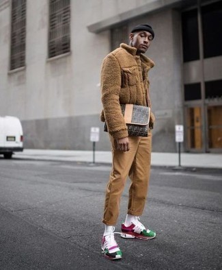 Модный мужской лук: светло-коричневая флисовая куртка-рубашка, светло-коричневые вельветовые брюки чинос, разноцветные кроссовки, серый кожаный мужской клатч