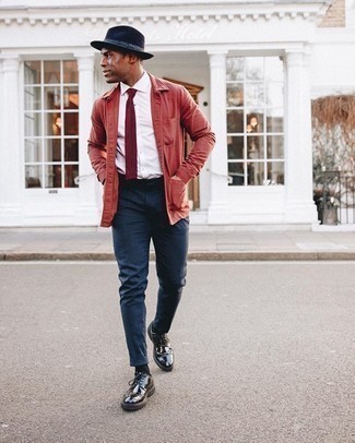 С чем носить темно-синюю шерстяную шляпу мужчине весна: Красная куртка-рубашка и темно-синяя шерстяная шляпа — прекрасная формула для воплощения модного и несложного ансамбля. Завершив ансамбль черными кожаными туфлями дерби, получим занятный результат. Когда зимний сезон отступает и сменяется более теплой погодой, подобный образ окажется по вкусу многим мужчинам.