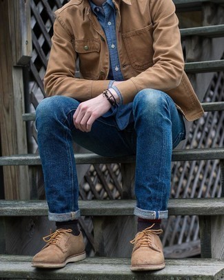 Как носить бежевые замшевые туфли дерби с синими джинсами осень в стиле смарт-кэжуал: Светло-коричневая куртка-рубашка и синие джинсы — обязательные вещи в гардеробе джентльменов с замечательным вкусом в одежде. Если ты любишь смешивать в своих луках разные стили, из обуви можешь надеть бежевые замшевые туфли дерби. Разумеется, подобное сочетание будет отличной идеей для пасмурной погоды.