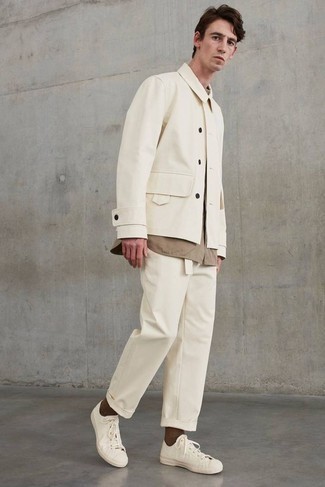 С чем носить бежевую куртку-рубашку в 30 лет мужчине в теплую погоду: Образ из бежевой куртки-рубашки и бежевых брюк чинос поможет выглядеть аккуратно, а также выразить твой индивидуальный стиль. Почему бы не добавить в этот лук чуточку авантюрности с помощью белых низких кед из плотной ткани?