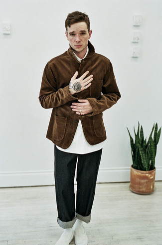Модный лук: темно-коричневая вельветовая куртка-рубашка, белая рубашка с коротким рукавом, черные джинсы, белые слипоны из плотной ткани