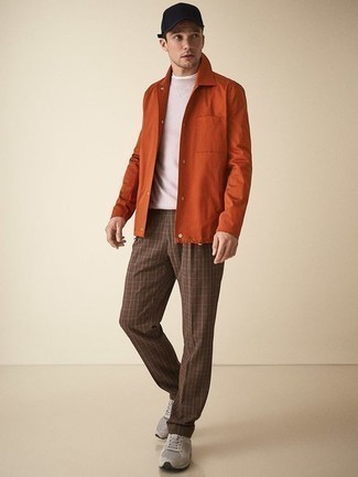 С чем носить брюки в шотландскую клетку мужчине осень в стиле кэжуал: Оранжевая куртка-рубашка чудесно сочетается с брюками в шотландскую клетку. В паре с этим ансамблем наиболее гармонично выглядят серые кроссовки. Нечего и говорить, такой ансамбль станет отличной идеей в осеннее время года.