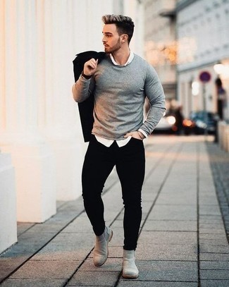 Как носить серый свитер с круглым вырезом с черными зауженными джинсами мужчине в теплую погоду: Серый свитер с круглым вырезом в сочетании с черными зауженными джинсами однозначно будет привлекать взоры прекрасных дам. Не прочь добавить в этот лук нотку утонченности? Тогда в качестве обуви к этому образу, стоит обратить внимание на серые замшевые ботинки челси.