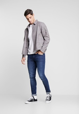 С чем носить зауженные джинсы мужчине: Серая куртка-рубашка в шотландскую клетку и зауженные джинсы позволят создать нескучный и модный образ. Великолепно сюда подойдут черно-белые низкие кеды из плотной ткани.