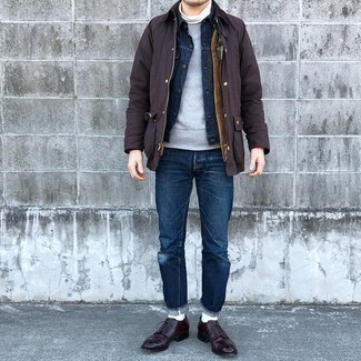 Как носить серый свитшот с темно-синей джинсовой курткой в 30 лет мужчине в прохладную погоду в стиле смарт-кэжуал: Сочетание темно-синей джинсовой куртки и серого свитшота — хорошая идея для воплощения мужского лука в стиле smart casual. Если ты не боишься соединять в своих образах разные стили, из обуви можешь надеть темно-красные кожаные туфли дерби.
