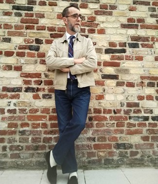 Как одеваться мужчине за 50: Бежевая куртка харрингтон и темно-синие джинсы — прекрасный вариант для несложного, но модного мужского ансамбля.