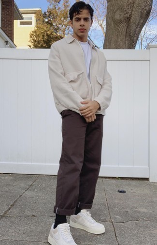 Как носить куртку харрингтон с низкими кедами в 20 лет: Дуэт куртки харрингтон и темно-коричневых брюк чинос позволит выглядеть по моде, но при этом выразить твою индивидуальность. Ну и почему бы не разнообразить ансамбль с помощью низких кед?