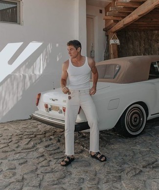 С чем носить белые джинсы мужчине в жару в спортивном стиле: Белая майка и белые джинсы — замечательная формула для создания стильного и функционального ансамбля. Этот образ органично завершат черные кожаные сандалии.