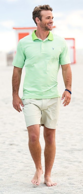 С чем носить зеленую футболку-поло в 20 лет мужчине в жару: Если ты любишь одеваться с иголочки, чувствуя себя при этом комфортно и расслабленно, тебе стоит опробировать это сочетание зеленой футболки-поло и бежевых шорт.