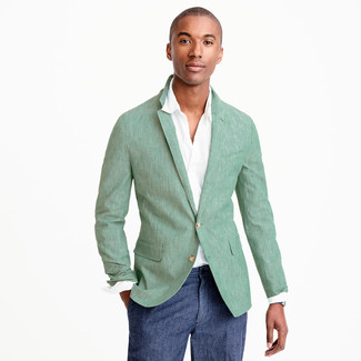 С чем носить зеленый пиджак мужчине в теплую погоду: Сочетание зеленого пиджака и темно-синих классических брюк — превосходный пример делового городского стиля.