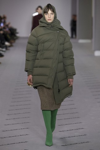 С чем носить юбку в холод: Оливковая куртка-пуховик и юбка — хорошая идея для несложного, но стильного образа.