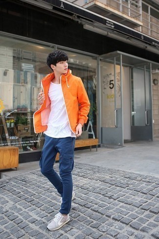 С чем носить оранжевую куртку подросткам мужчине в теплую погоду в стиле кэжуал: Оранжевая куртка идеально гармонирует с синими брюками карго. Закончив ансамбль серыми кроссовками, ты привнесешь в него динамичность.