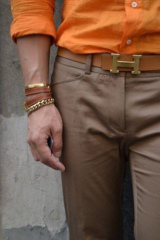 Как носить оранжевую классическую рубашку с коричневыми классическими брюками мужчине лето: Оранжевая классическая рубашка в сочетании с коричневыми классическими брюками позволит воплотить строгий деловой стиль. Как по нам, так это очень комфортное и простое сочетание для летнего сезона.