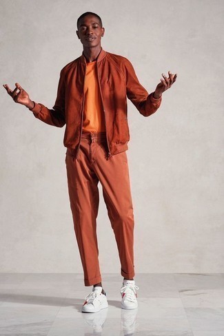 С чем носить оранжевые брюки мужчине: Несмотря на свою легкость, образ из оранжевого бомбера и оранжевых брюк неизменно нравится джентльменам, неизбежно покоряя при этом дамские сердца. Любители модных экспериментов могут завершить ансамбль бело-темно-синими кожаными низкими кедами, тем самым добавив в него немного классики.