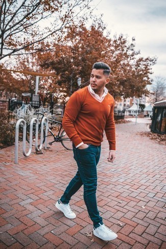 С чем носить кожаные кеды в 30 лет мужчине весна: Комбо из оранжевого свитера с v-образным вырезом и темно-синих джинсов — замечательная идея для воплощения мужского образа в стиле smart casual. И почему бы не разбавить образ с помощью кожаных кед? Когда зимняя пора отступает и сменяется в весенне-осенний период, хочется одеваться со вкусом и выглядеть роскошно, обращая на себя взоры прекрасных девушек. Подобное сочетание одежды безусловно в этом поможет.