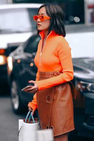 С чем носить оранжевые солнцезащитные очки женщине: Если ты любишь выглядеть красиво и при этом чувствовать себя комфортно и нескованно, опробируй это сочетание оранжевого свитера с воротником на молнии и оранжевых солнцезащитных очков.