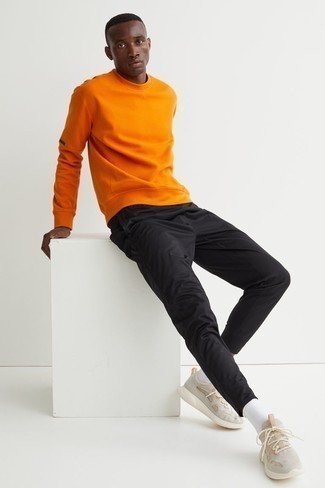 С чем носить оранжевый свитшот мужчине: Сочетание оранжевого свитшота и черных брюк чинос позволит создать модный мужской лук. Тебе нравятся смелые сочетания? Можешь завершить свой ансамбль бежевыми кроссовками.