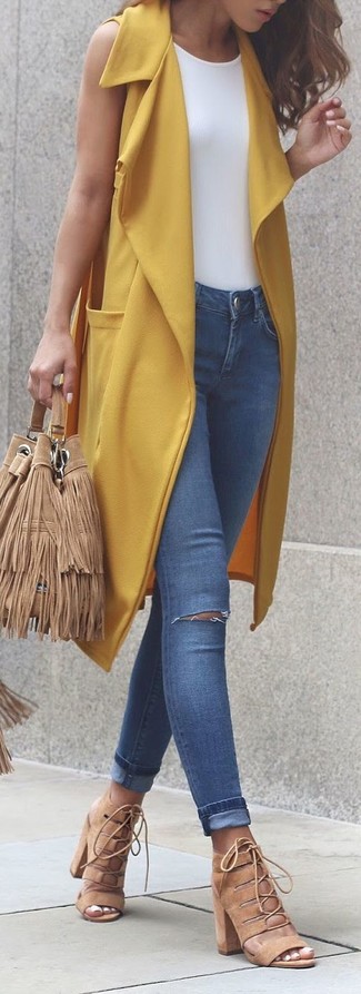 С чем носить синие рваные джинсы женщине: Желтое пальто без рукавов в паре с синими рваными джинсами позволит выразить твой запоминающийся стиль. Вместе с этим нарядом органично будут смотреться светло-коричневые замшевые босоножки на каблуке.