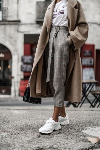 С чем носить темно-серые брюки женщине в холод в стиле кэжуал: Светло-коричневое пальто в сочетании с темно-серыми брюками позволит выразить твою индивидуальность и выделиться из серой массы. Белые кроссовки гарантируют комфорт в движении.