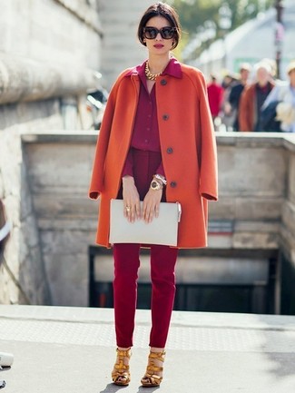 Как носить темно-красные узкие брюки с оранжевым пальто в холод в деловом стиле: Оранжевое пальто в паре с темно-красными узкими брюками — прекрасный пример модного офисного стиля. В качестве дополнения к образу сюда напрашиваются золотые кожаные босоножки на каблуке.