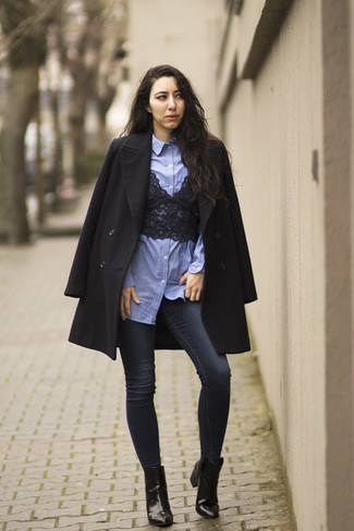 С чем носить темно-синие джинсы скинни в 30 лет в холод в стиле смарт-кэжуал: Черное пальто и темно-синие джинсы скинни — необходимые вещи в гардеробе стильной женщины. В паре с этим луком наиболее выигрышно выглядят черные кожаные ботильоны.