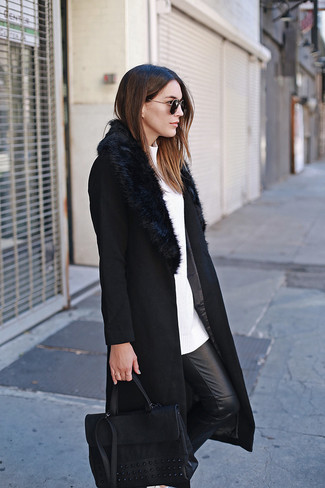 Женские луки в холод: Сочетание черного пальто с меховым воротником и черных кожаных узких брюк — образец современного стиля в большом городе.