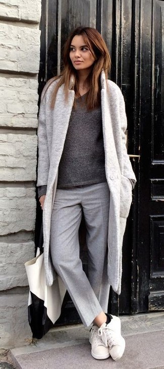 Какие низкие кеды носить с серым пальто женщине в теплую погоду: Серое пальто и серые шерстяные классические брюки позволят создать нескучный образ для офиса. Почему бы не добавить в этот наряд чуточку небрежности с помощью низких кед?