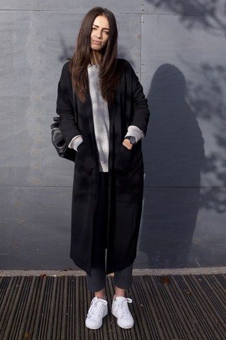 С чем носить шерстяные брюки женщине в теплую погоду в стиле смарт-кэжуал: Черное пальто и шерстяные брюки — хороший выбор для создания лука в стиле business casual. Пара белых низких кед свяжет лук воедино.