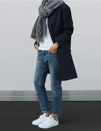 С чем носить синие джинсы женщине в прохладную погоду в стиле смарт-кэжуал: Черное пальто и синие джинсы — обязательные предметы в арсенале поклонниц стиля casual. Этот образ великолепно дополнят белые низкие кеды.