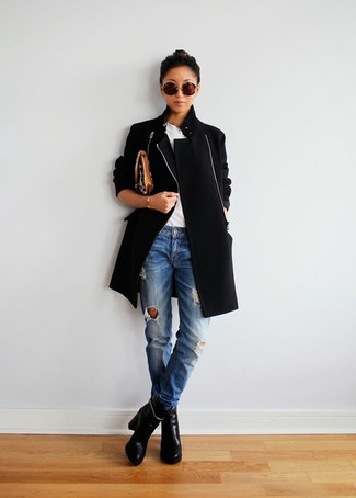 С чем носить черно-белую обувь в прохладную погоду в стиле кэжуал: Черное пальто в сочетании с синими рваными джинсами — классная идея для воплощения наряда в стиле business casual. В паре с этим луком наиболее удачно будут смотреться черные кожаные ботильоны.