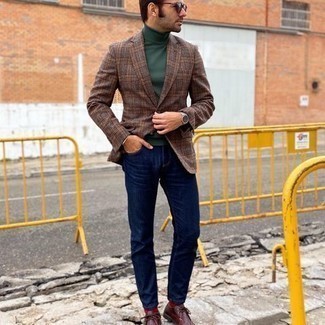 С чем носить темно-коричневый пиджак в шотландскую клетку мужчине в стиле смарт-кэжуал: Дуэт темно-коричневого пиджака в шотландскую клетку и темно-синих джинсов как нельзя лучше подчеркнет твою мужественность. В паре с этим луком наиболее уместно выглядят темно-красные кожаные ботинки дезерты.