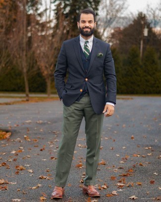 С чем носить оливковые классические брюки мужчине осень: Темно-синий пиджак и оливковые классические брюки — хороший пример элегантного стиля в одежде. В этот образ легко интегрировать коричневые кожаные лоферы. Нам кажется, это суперский выбор в прохладную осеннюю погоду.