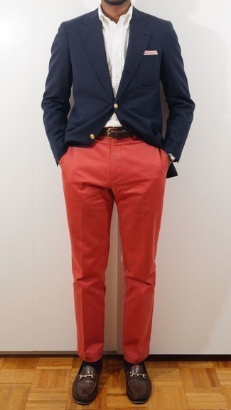 Как носить темно-синий пиджак с красными брюками чинос: Надев темно-синий пиджак и красные брюки чинос, можно спокойно отправляться на неофициальную встречу или культурное мероприятие. Закончив образ темно-коричневыми кожаными лоферами, получим занятный результат.