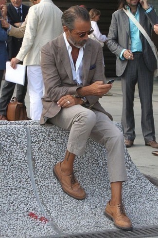 С чем носить оливковые солнцезащитные очки мужчине: Сочетание серого пиджака и оливковых солнцезащитных очков - очень практично, и поэтому прекрасно подойдет для повседневой носки. Хотел бы сделать лук немного элегантнее? Тогда в качестве дополнения к этому ансамблю, выбирай светло-коричневые кожаные броги.