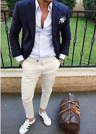 Как носить голубую классическую рубашку с светло-коричневыми брюками чинос в теплую погоду: Голубая классическая рубашка и светло-коричневые брюки чинос — беспроигрышный вариант для воплощения мужского образа в стиле business casual. Дополнив образ бело-черными низкими кедами из плотной ткани, ты привнесешь в него немного динамичности.