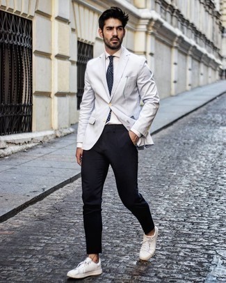 С чем носить темно-сине-белый галстук с принтом в 30 лет мужчине в стиле смарт-кэжуал: Серый пиджак и темно-сине-белый галстук с принтом — беспроигрышный вариант для светского мероприятия. Белые кожаные низкие кеды создадут легкое настроение.