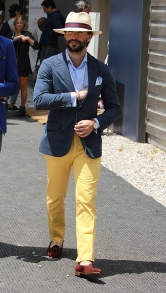 Как носить желтые брюки чинос с табачными замшевыми лоферами с кисточками лето в стиле смарт-кэжуал: Темно-синий пиджак в вертикальную полоску в паре с желтыми брюками чинос — беспроигрышный офисный вариант для джентльменов. И почему бы не привнести в повседневный ансамбль немного стильной строгости с помощью табачных замшевых лоферов с кисточками? Подобный образ наверняка придется тебе по вкусу в жаркие летние деньки.
