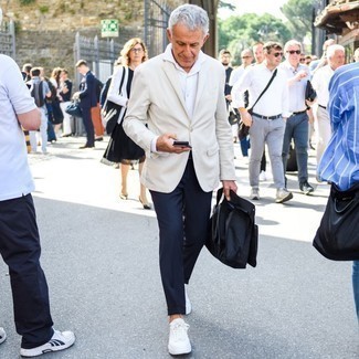 С чем носить синие брюки чинос за 50 лет: Если ты принадлежишь к той когорте парней, которые одеваются стильно, тебе понравится тандем бежевого пиджака и синих брюк чинос. Если ты любишь экспериментировать, на ноги можешь надеть белые низкие кеды из плотной ткани.