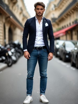 Модный мужской лук: темно-синий пиджак, белая классическая рубашка, синие джинсы, белые кожаные низкие кеды