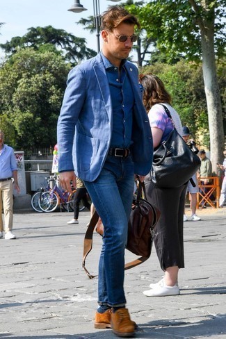 Как носить синие джинсы с синей классической рубашкой мужчине в теплую погоду: Согласись, сочетание синей классической рубашки и синих джинсов смотрится очень выигрышно? Любишь эксперименты? Закончи лук табачными замшевыми туфлями дерби.