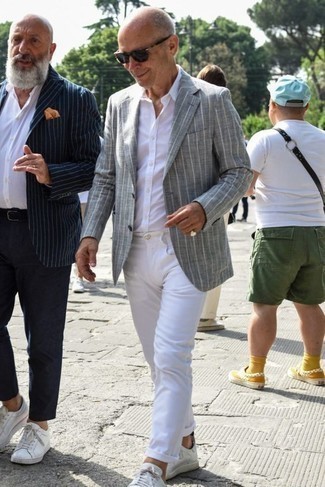 Как носить белую классическую рубашку с серым пиджаком в вертикальную полоску за 60 лет мужчине в стиле смарт-кэжуал: Несмотря на то, что это классический образ, сочетание серого пиджака в вертикальную полоску и белой классической рубашки приходится по вкусу стильным мужчинам, покоряя при этом сердца прекрасных дам. Почему бы не добавить в этот образ немного небрежности с помощью белых кожаных низких кед?