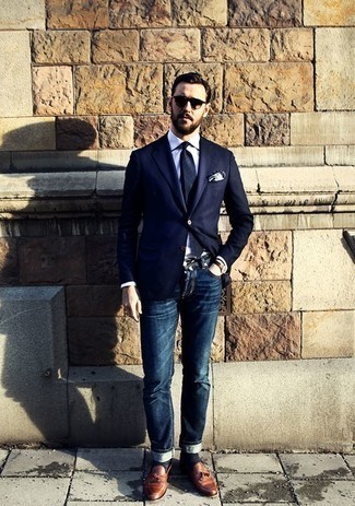 Как носить темно-синие джинсы с темно-коричневыми кожаными лоферами с кисточками: Сочетание темно-синего пиджака и темно-синих джинсов — прекрасный пример непринужденного офисного стиля для парней. Дополнив образ темно-коричневыми кожаными лоферами с кисточками, можно привнести в него немного привлекательного консерватизма.