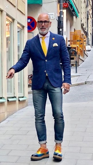 С чем носить темно-сине-белый пиджак в шотландскую клетку за 50 лет мужчине лето в стиле смарт-кэжуал: Темно-сине-белый пиджак в шотландскую клетку в паре с темно-синими зауженными джинсами поможет создать стильный мужской лук. Если ты предпочитаешь смелые решения в своих ансамблях, дополни этот разноцветными кожаными туфлями дерби. Такой ансамбль определенно тебе полюбится в жаркие дни.