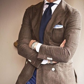 С чем носить темно-сине-белый вязаный галстук мужчине в деловом стиле: Несмотря на то, что это классический лук, образ из коричневого пиджака и темно-сине-белого вязаного галстука неизменно нравится стильным мужчинам, покоряя при этом сердца прекрасных дам.