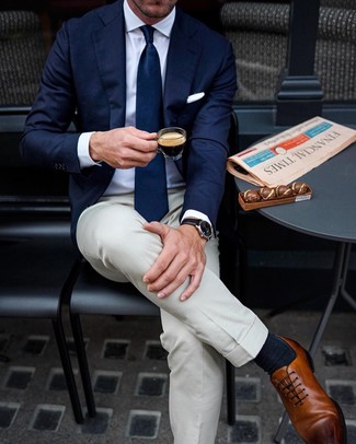 Как носить бело-темно-синюю классическую рубашку с светло-коричневыми классическими брюками мужчине: Бело-темно-синяя классическая рубашка и светло-коричневые классические брюки — прекрасный выбор для мероприятия в фешенебельном заведении. В сочетании с этим образом наиболее уместно будут выглядеть коричневые кожаные оксфорды.