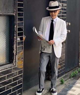 С чем носить черно-белые низкие кеды из плотной ткани за 60 лет мужчине: Белый пиджак в паре с серыми классическими брюками — хороший пример делового городского стиля. Не прочь поэкспериментировать? Тогда дополни образ черно-белыми низкими кедами из плотной ткани.