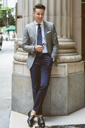С чем носить серый пиджак мужчине в теплую погоду: Серый пиджак в паре с темно-синими классическими брюками поможет создать стильный и мужественный образ. Пара черных кожаных лоферов с кисточками свяжет образ воедино.