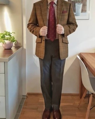 Как носить коричневый пиджак в шотландскую клетку с серыми классическими брюками мужчине: Сочетание коричневого пиджака в шотландскую клетку и серых классических брюк позволит воссоздать элегантный стиль. В сочетании с этим ансамблем великолепно смотрятся темно-красные кожаные туфли дерби.